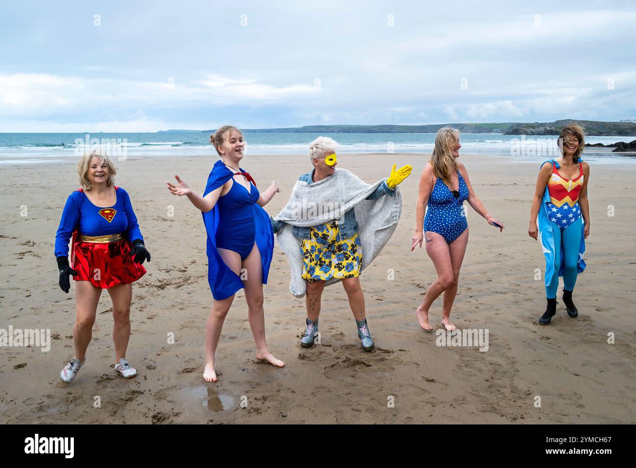 Die Teilnehmer treffen sich am Strand von Towan und bereiten sich auf die jährliche Veranstaltung „Superhero in the Cold“ vor, um Spenden für die britische Krebsforschung zu sammeln. Stockfoto