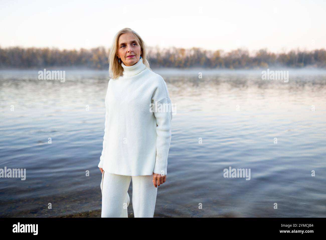 Porträt einer Frau im weißen Pullover am Seeufer Stockfoto