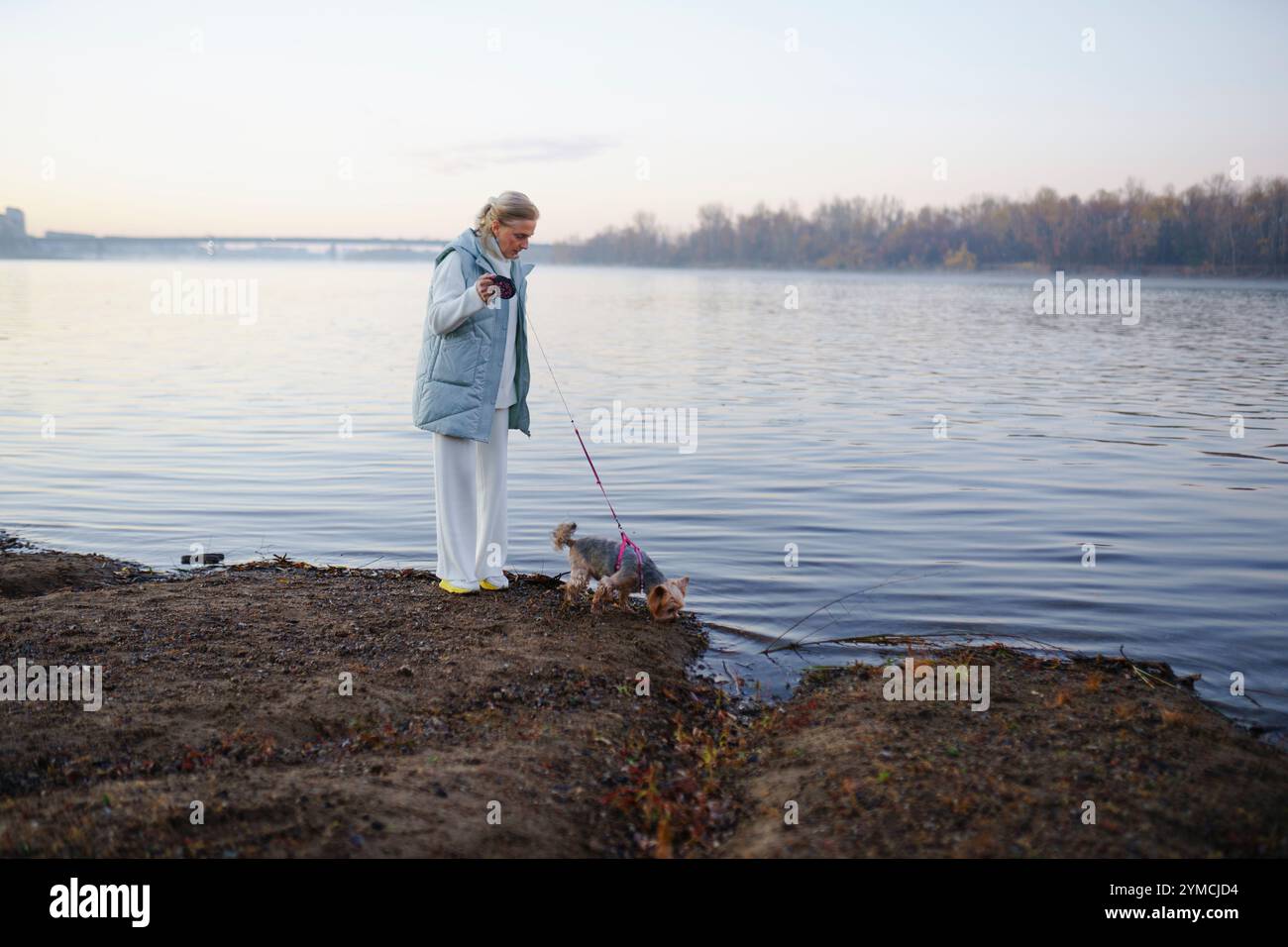 Frau mit Yorkshire Terrier am Seeufer Stockfoto