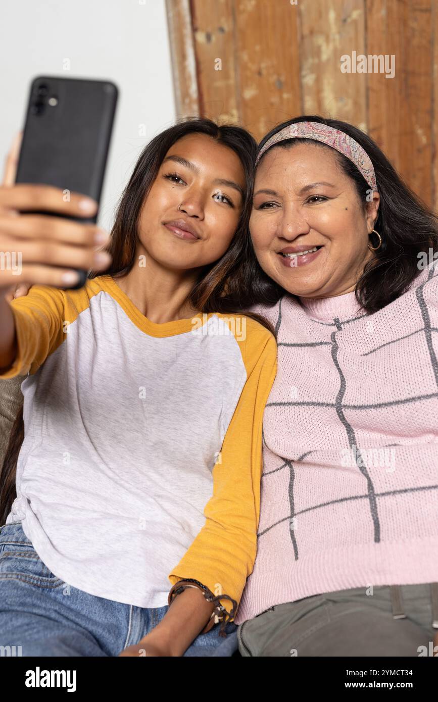 asiatische Teenagerin und Oma machen zu Hause Selfie und teilen freudige Momente Stockfoto