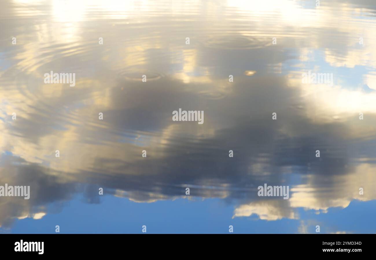 Reflexion des Himmels im Wasser. Schneeweiße Wolken spiegeln sich im blauen Wasser. Stockfoto