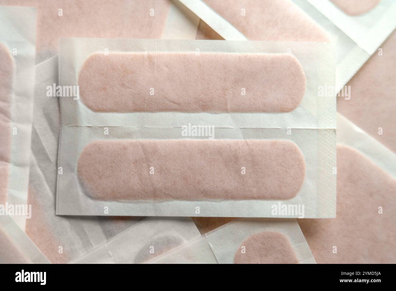 Nahaufnahme steriler Haftverbände in Einzelverpackung zur Wundversorgung und erste Hilfe. Weiches Licht unterstreicht ihr hygienisches Design. Draufsicht Stockfoto