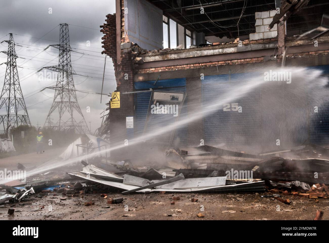 East London der Ort des Lower Lea Valley des London Olympic Games Park 2012, 26. Juli 2007. Der symbolische Beginn des Abbruchs des alten, bereit für das neue, ein Pressefotobesuch vor Ministern und Mitgliedern der Olympischen Zustellbehörde. Die Capital Print and Data Factory, ein Stromschlauch schießt Wasser aus, um den Staub, der vom Abbruchteam erzeugt wurde, zu dämpfen. Marshgate Lane, Stratford, London E15. HOMER SYKES AUS DEN 2000ER JAHREN Stockfoto