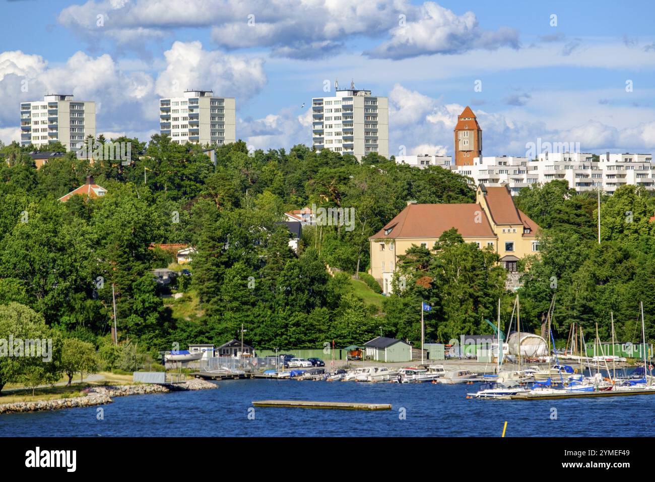 Eine Küstenstadt mit Segelbooten und mehrstöckigen Wohnhäusern inmitten einer grünen Landschaft, Archipel, stockholm, schweden Stockfoto