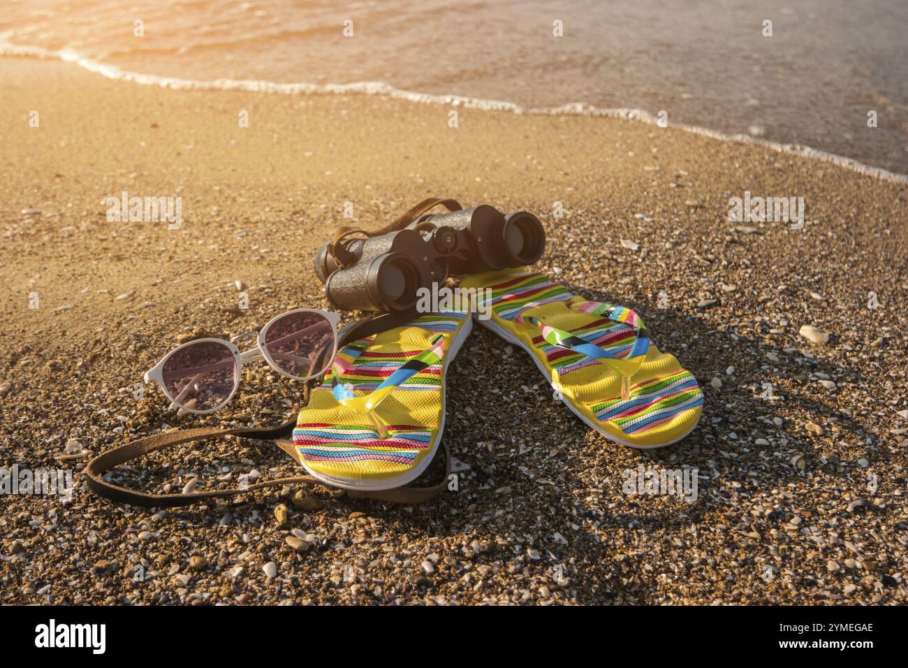 Fernglas mit Flipflops. Sonnenbrille mit weißem Rahmen. Neue Horizonte warten. Seien Sie bereit für Abenteuer Stockfoto