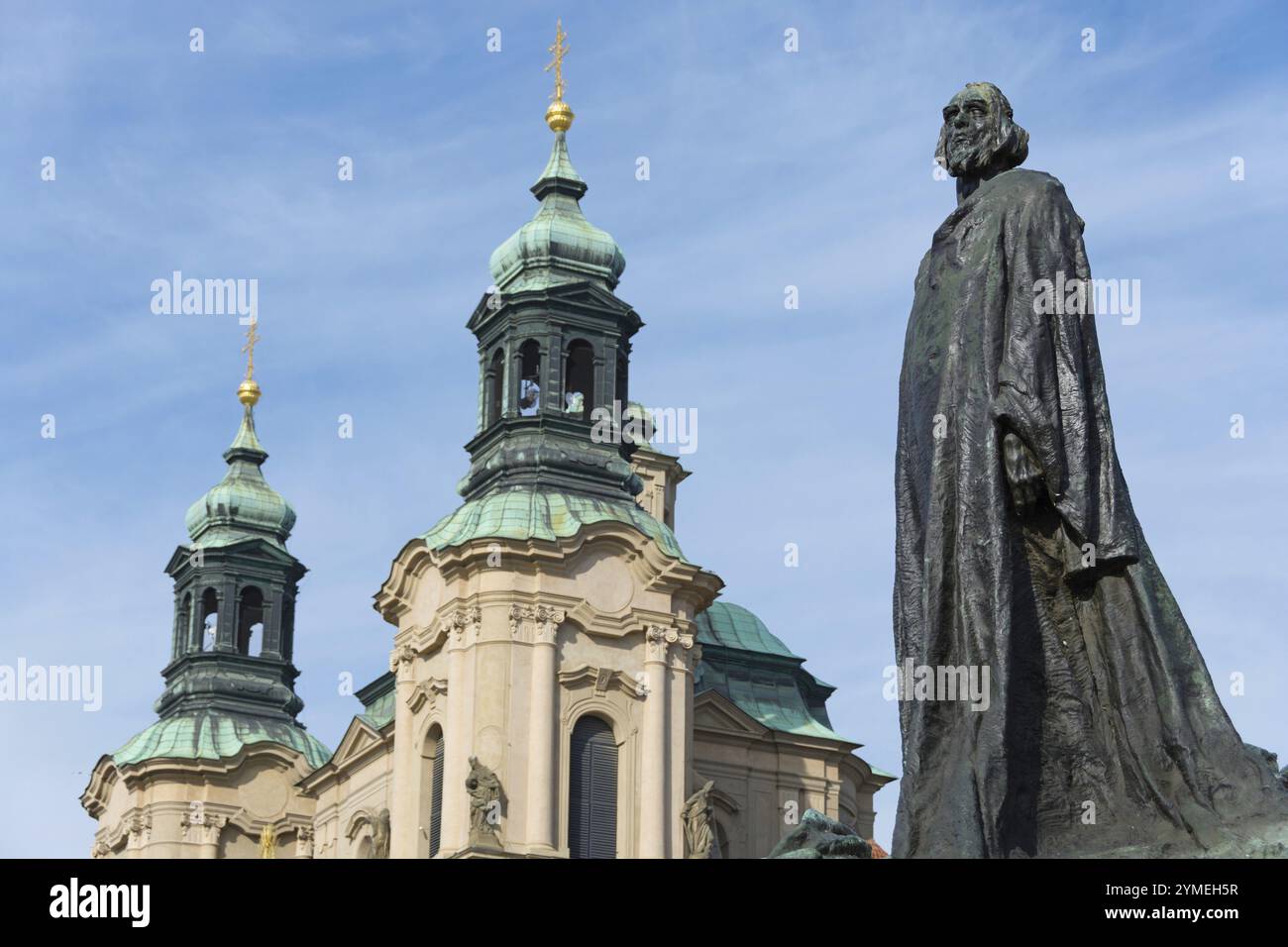 Jan-Hus-Denkmal mit der St.-Nikolaus-Kirche im Hintergrund Stockfoto