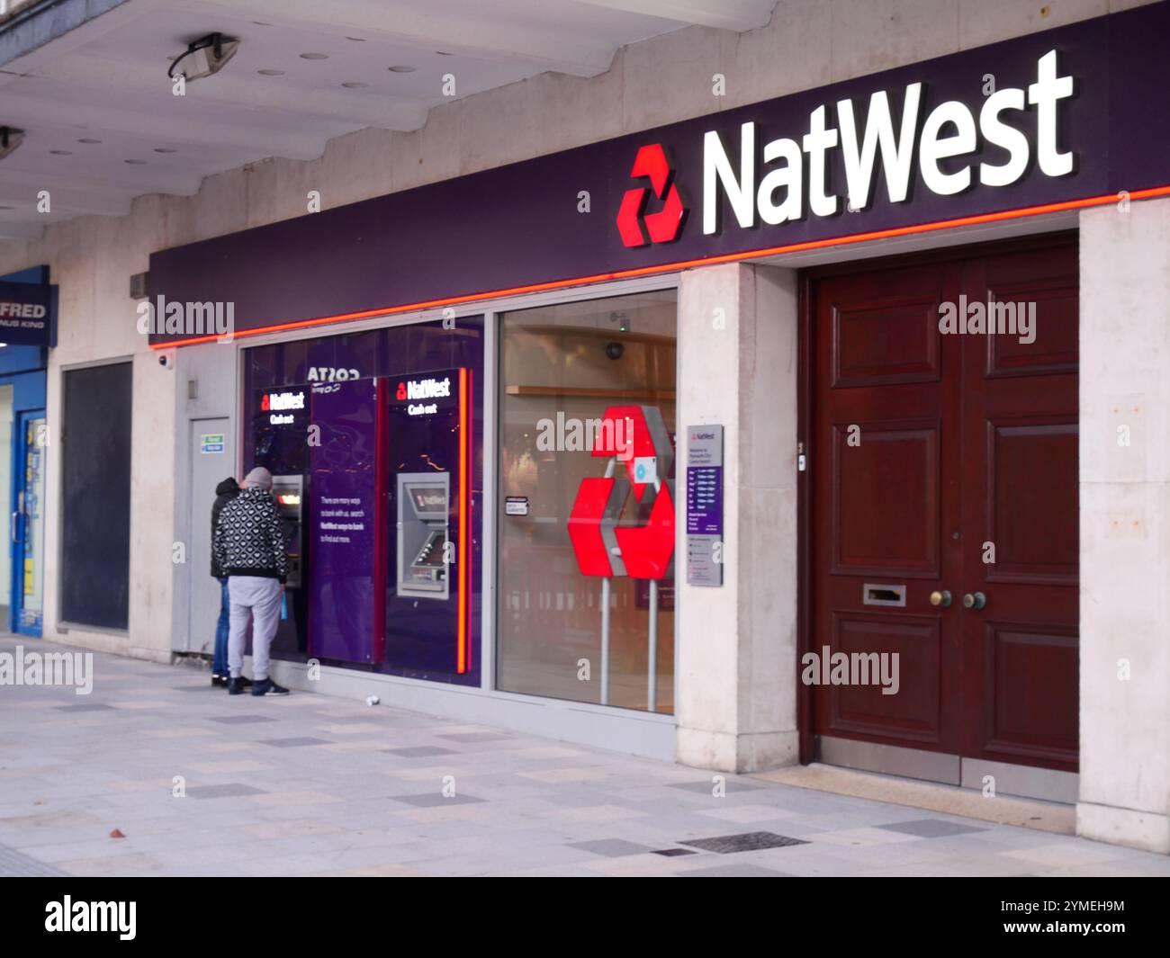 NatWest Bankfiliale mit Leuten, die einen Geldautomaten außerhalb des Gebäudes benutzen. Plymouth, Großbritannien Stockfoto