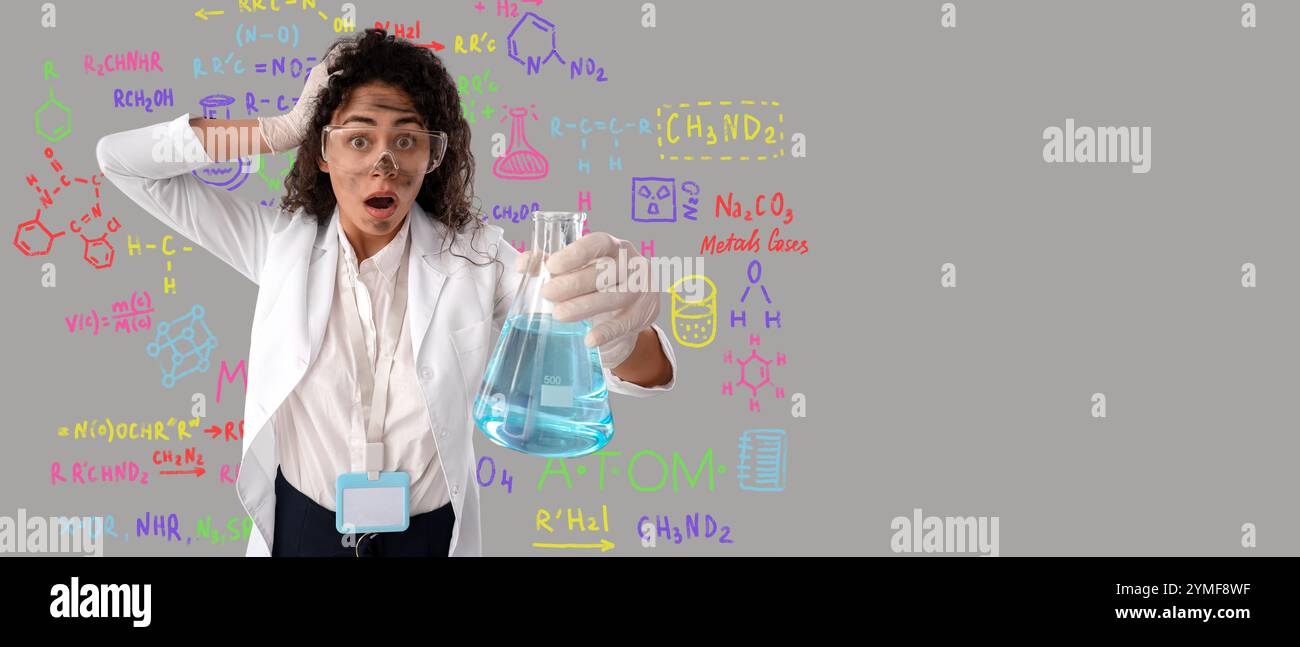 Schockierte afroamerikanische Chemikerin mit schmutzigem Gesicht als Folge einer Explosion auf grauem Hintergrund mit Platz für Text Stockfoto