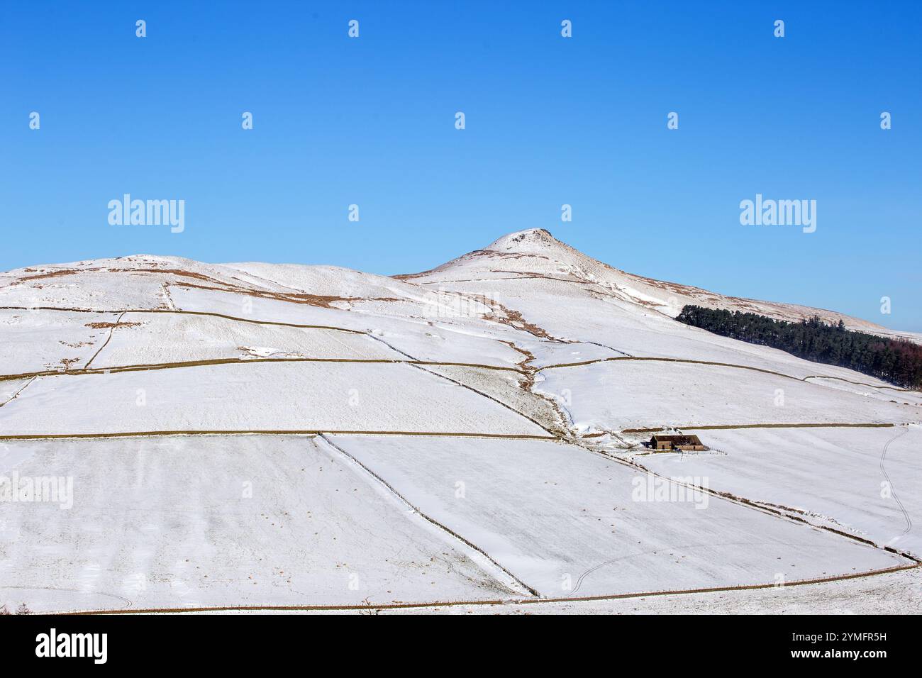 Shutlingsloe Hill in einer schneebedeckten Winterlandschaft des Cheshire Peak District mit einem einsamen Bauernhaus Stockfoto