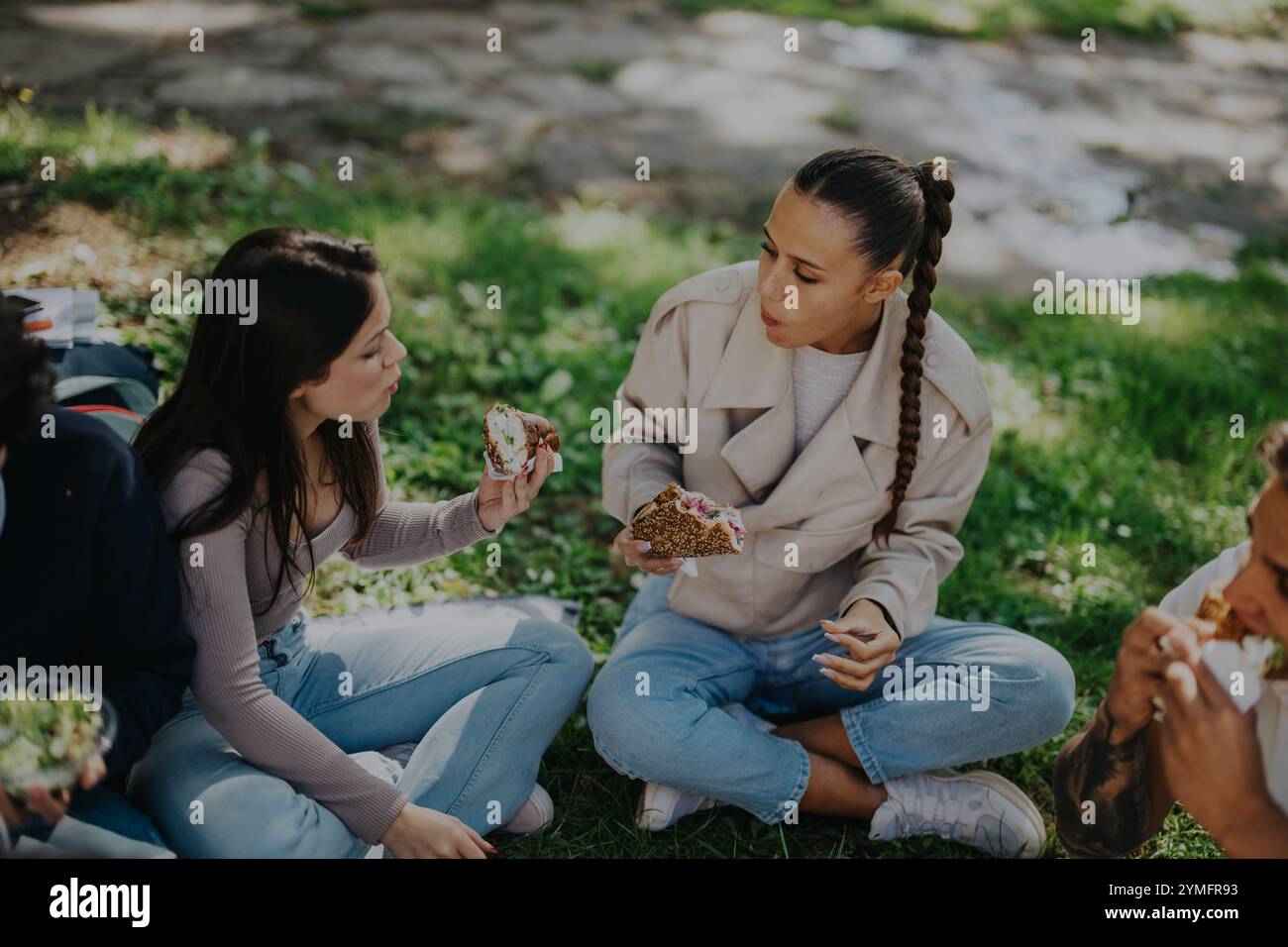 Eine Gruppe von Schülern genießt gemeinsam ein Mittagessen im Park Stockfoto