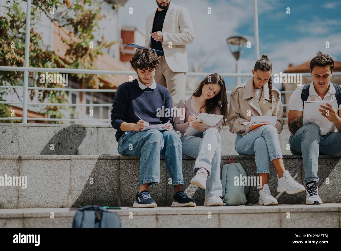 Schülerinnen und Schüler lernen im Freien unter Anleitung des Lehrers Stockfoto