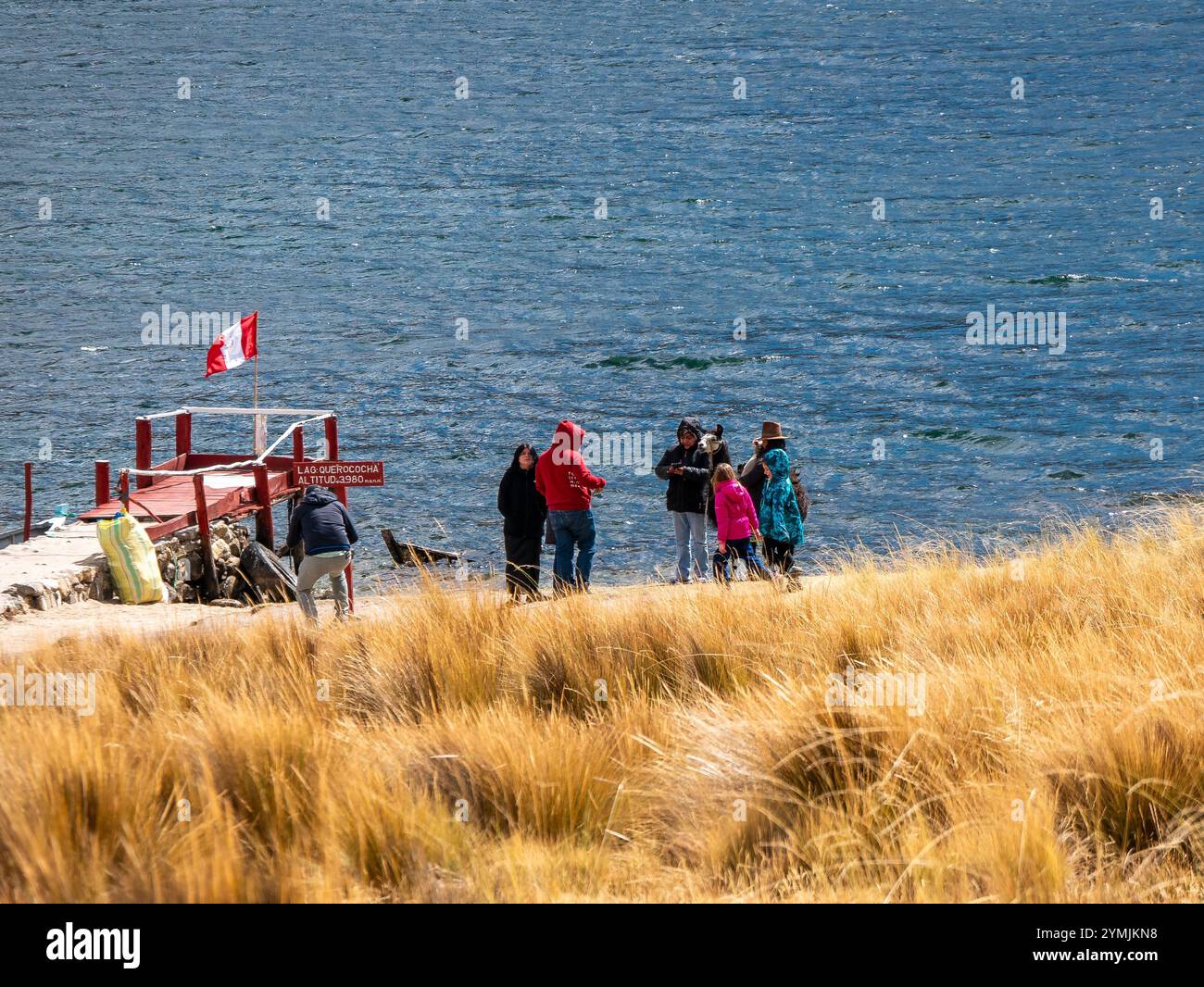 Ancash, Peru - 25. Juli 2024: Touristen machen Fotos mit der Querococha Lagune im Hintergrund Stockfoto