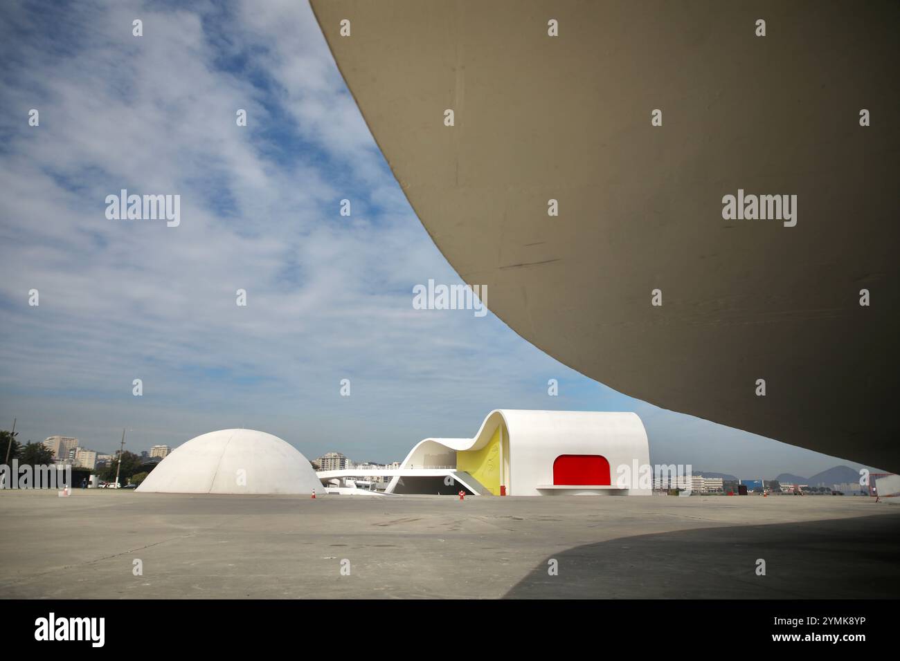 Das Memorial Roberto Silveira (links), das 2003 eröffnet wurde, und das Oscar Niemeyer Popular Theater (rechts), das 2007 eröffnet wurde, sind abgebildet. Sie sind Teil des „Niemeyer Way“, einer Serie von sieben Gebäuden, die Oscar Niemeyer in Niterói, Brasilien, entwarf. Oscar Niemeyer ist einer der berühmtesten Architekten Brasiliens. Er gehört der International Style Movement an. Er ist bekannt für den Bau der brasilianischen Hauptstadt Brasilia mit dem Stadtplaner Lúcio Costa, der 1960 eröffnet wurde. Niteroi, gegenüber der Guanabara-Bucht von Rio de Janeiro, ist nach Brasilia die zweite Stadt der Welt mit den meisten Niemeyer-Gebäuden Stockfoto