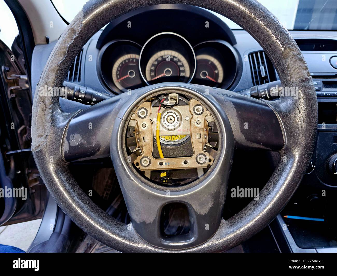 Austausch der Wickelfeder des Airbag-Spiralkabels durch Risse des beschädigten Gummis des Lenkrads des Fahrzeugs; das Kabel speichert Energie auf einer rotierenden Achse. Stockfoto