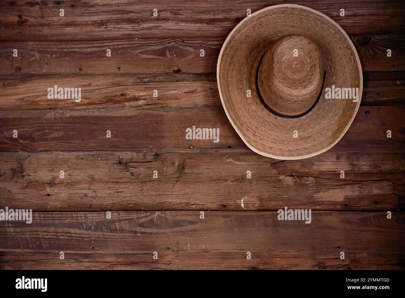 Strohhut auf Holzwand Stockfoto