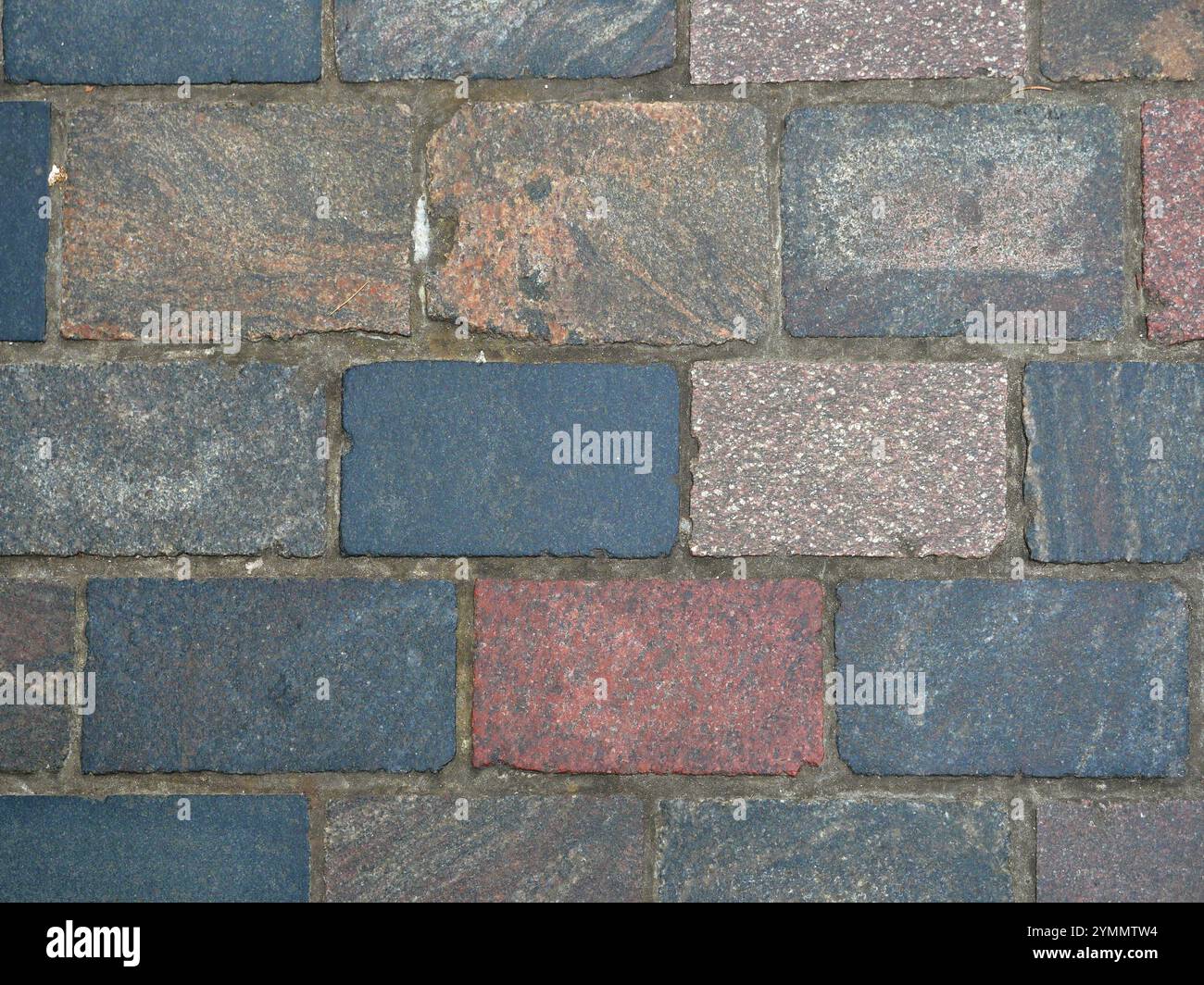 Straßenpflaster - Granitpflaster - farbenfrohe Granitpflaster in einer Fußgängerzone. Die vielfältigen Farben schaffen eine einladende Atmosphäre. Stockfoto