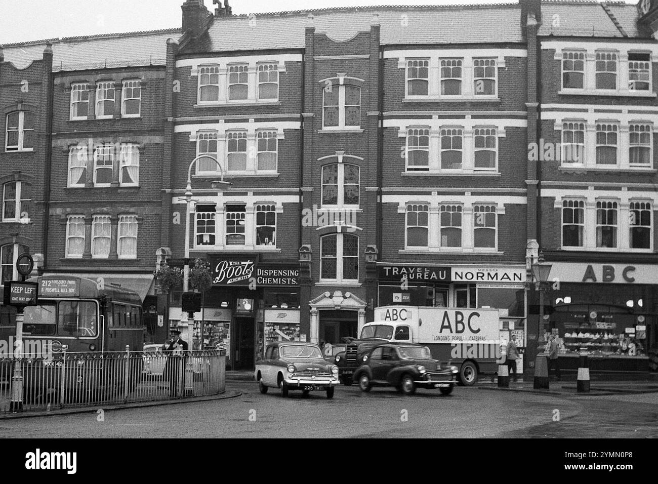 Straßenszene im Norden Londons, mit „Boots Dispening Chemists“ und einer „ABC“-Cafeteria und Lieferwagen, 1950er Jahre Stockfoto