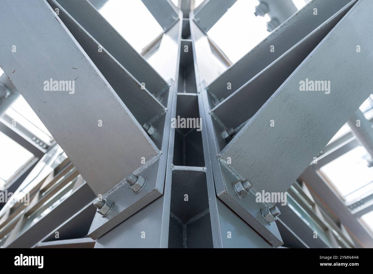 Graue Metallsäule und Träger, verbunden mit Bolzen, Nahaufnahme. Abstraktes Hintergrundfoto der Industriearchitektur mit selektivem Weichfokus Stockfoto