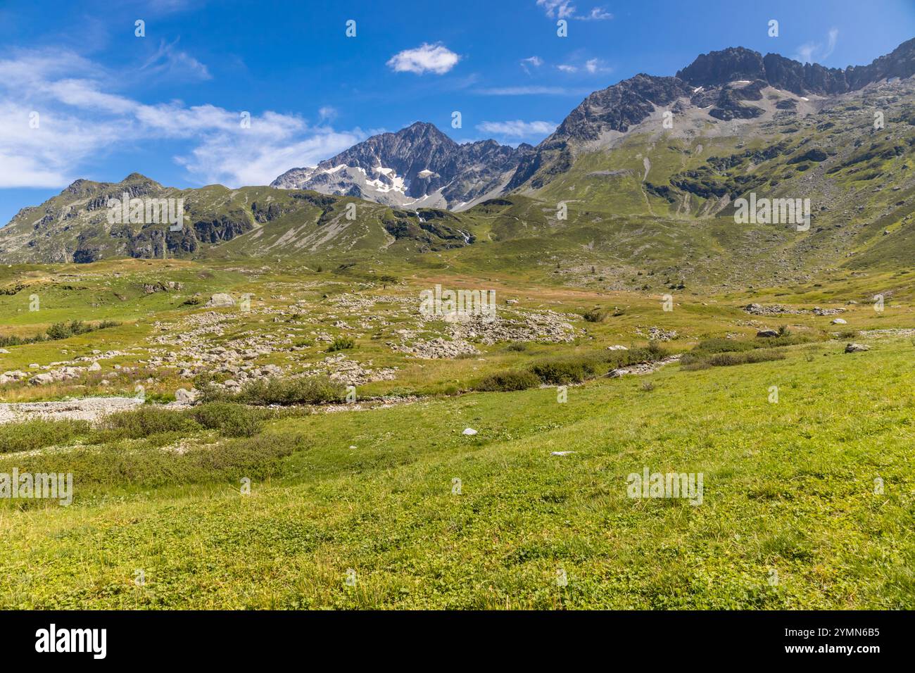 Tour du Mont Blanc wunderschöne Landschaften in den Alpen an einem sonnigen Sommertag. Grünes Gras auf der Almwiese umgeben von hohen Berggipfeln Stockfoto Tour du Mont Blanc wunderschöne Landschaften in den Alpen an einem sonnigen Sommertag. Grünes Gras auf der Almwiese umgeben von hohen Berggipfeln Stockfoto
