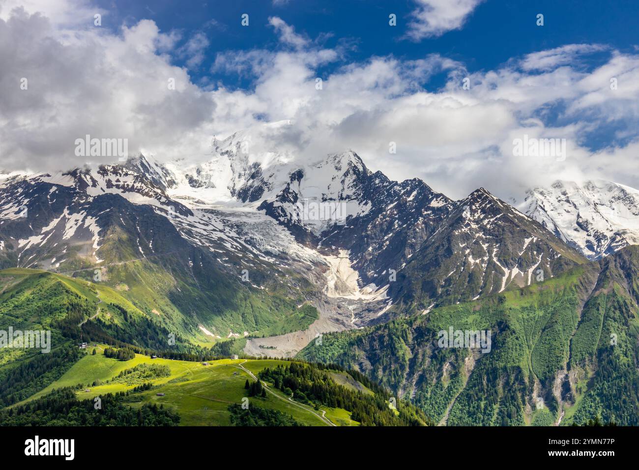 Tour du Mont Blanc wunderschöne Landschaften in den Alpen an einem sonnigen Sommertag. Grünes Gras auf der Almwiese umgeben von hohen Berggipfeln Stockfoto Tour du Mont Blanc wunderschöne Landschaften in den Alpen an einem sonnigen Sommertag. Grünes Gras auf der Almwiese umgeben von hohen Berggipfeln Stockfoto