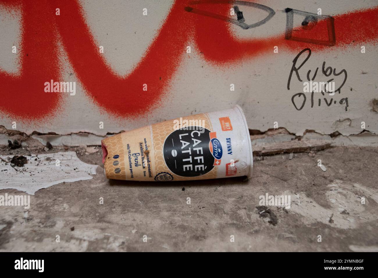 Yorkshire, Großbritannien : 31. Mai 2024 – Ein dünner Kaffeetasse zum Herausnehmen auf dem Boden eines verlassenen Gebäudes mit Graffiti Stockfoto