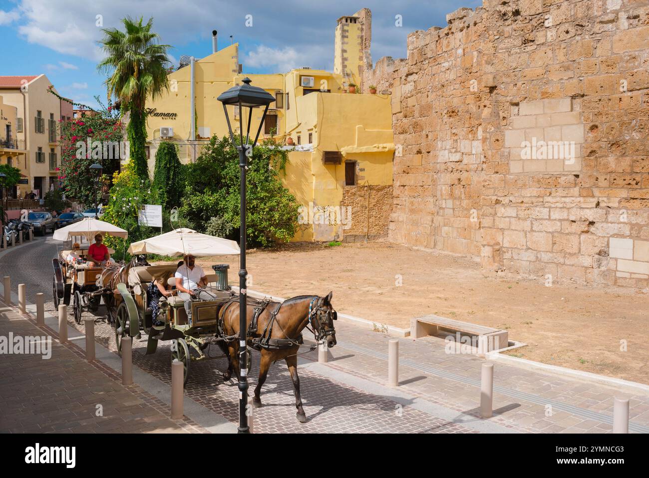 Kreta Tourismus, Blick im Sommer auf Touristen in Pferdekutschen, die eine Tour durch die alten venezianischen Stadtmauern in Chania (Hania), Kreta, Griechenland machen Stockfoto