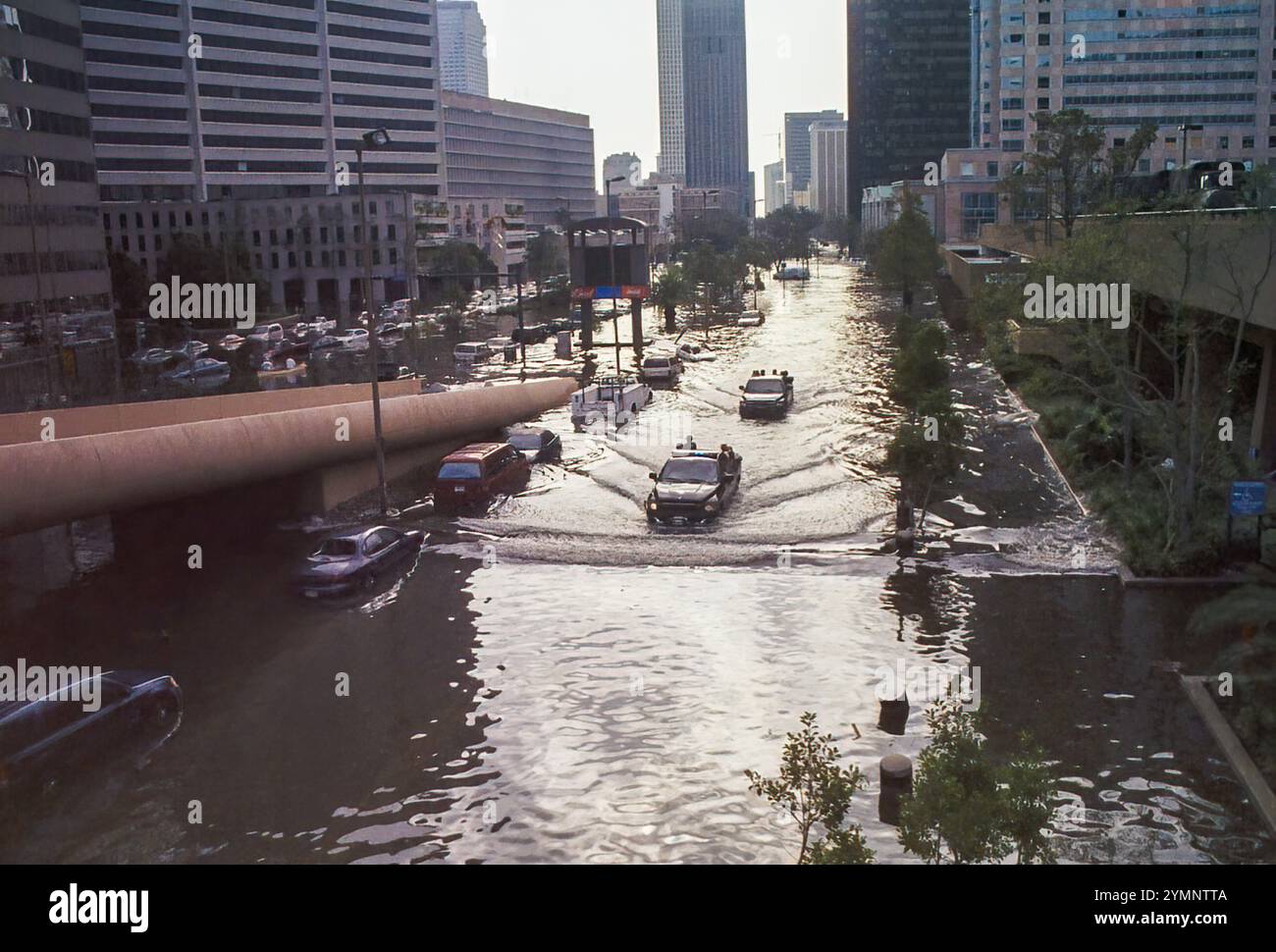 New Orleans, LA, USA - August 2005: Bild der Poydras Street im Stadtzentrum vom Superdome aus, das Straßenfluten zeigt, die nach dem Ausfall des Deiches der US Army Corps of Engineers nach Hurrikan Katrina aufgetreten sind. Das Foto zeigt das Ausmaß der Überschwemmung mit geparkten Fahrzeugen, beweglichen Fahrzeugen und Gebäuden mit ausgeblasenen Fenstern. Dieses Foto wurde mit einer 35-mm-Kamera aus dem Superdome aufgenommen, ein oder zwei Tage nach dem Sturm. Stockfoto