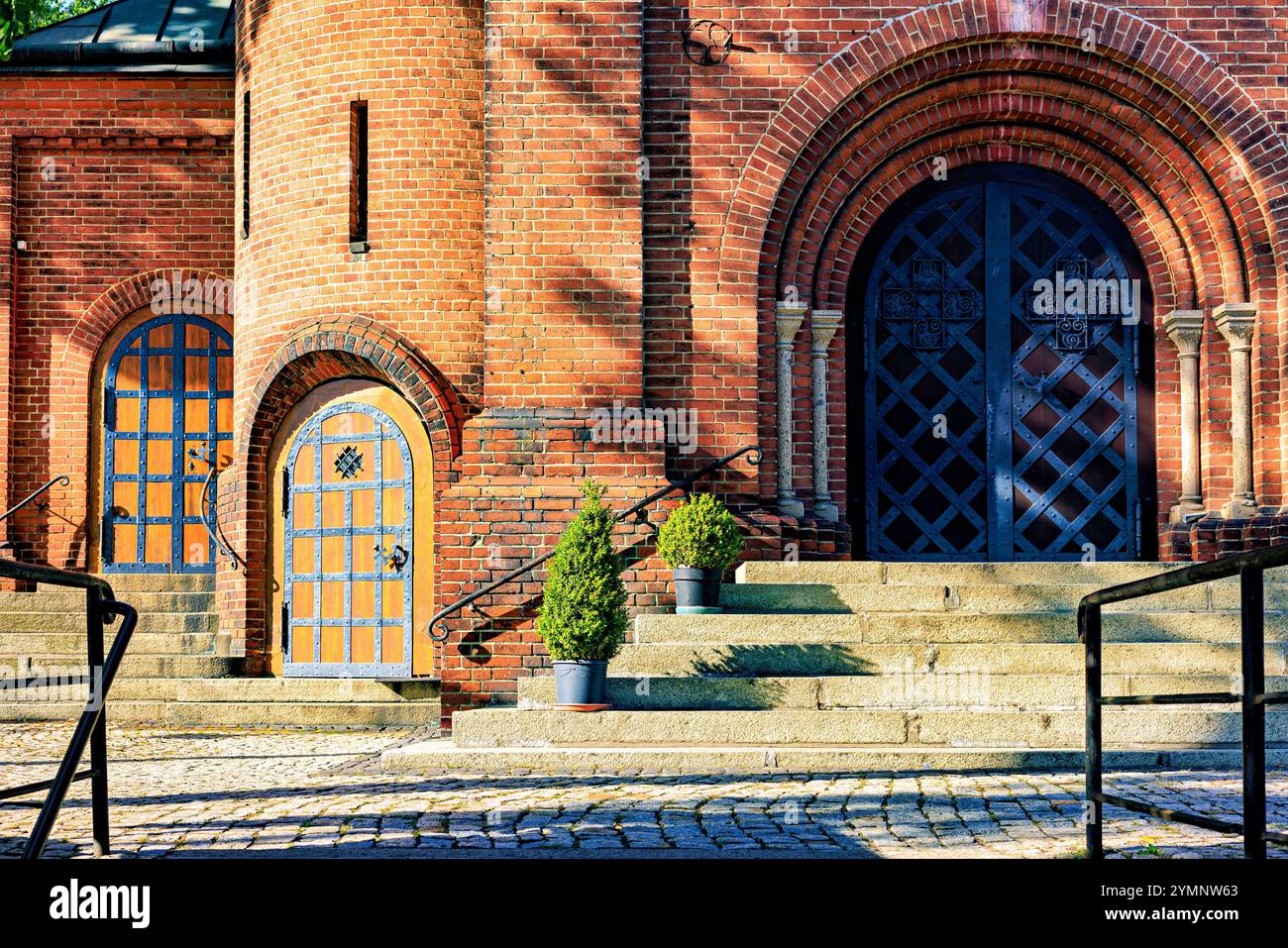 Die Fassade der katholischen Kirche hat Bogentüren, die mit Metall gepolstert sind. Hochwertige Fotos Stockfoto