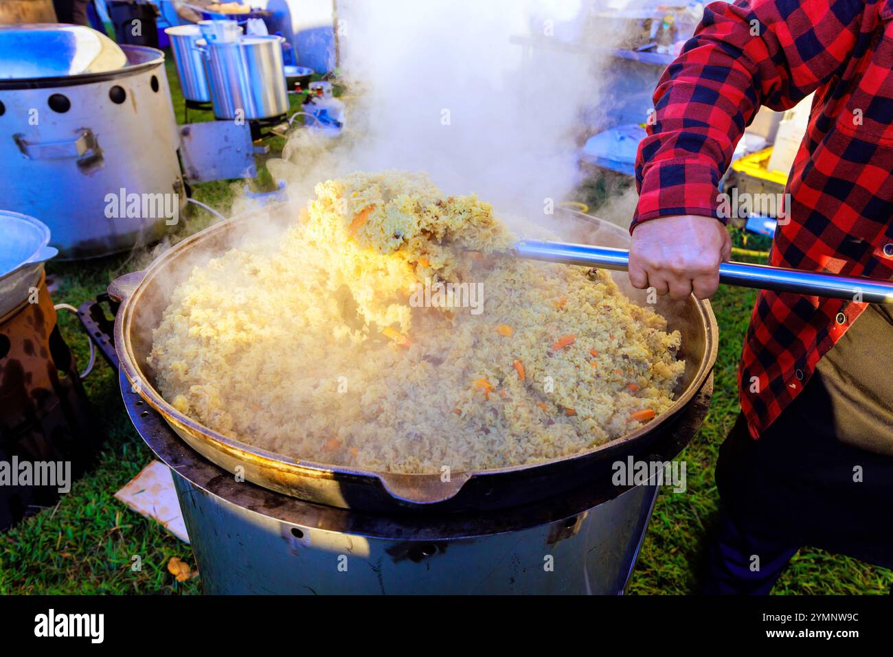 Traditionelles türkisches Pilaw wird in einem großen gusseisernen Kessel gekocht, während die Küche zubereitet wird Stockfoto