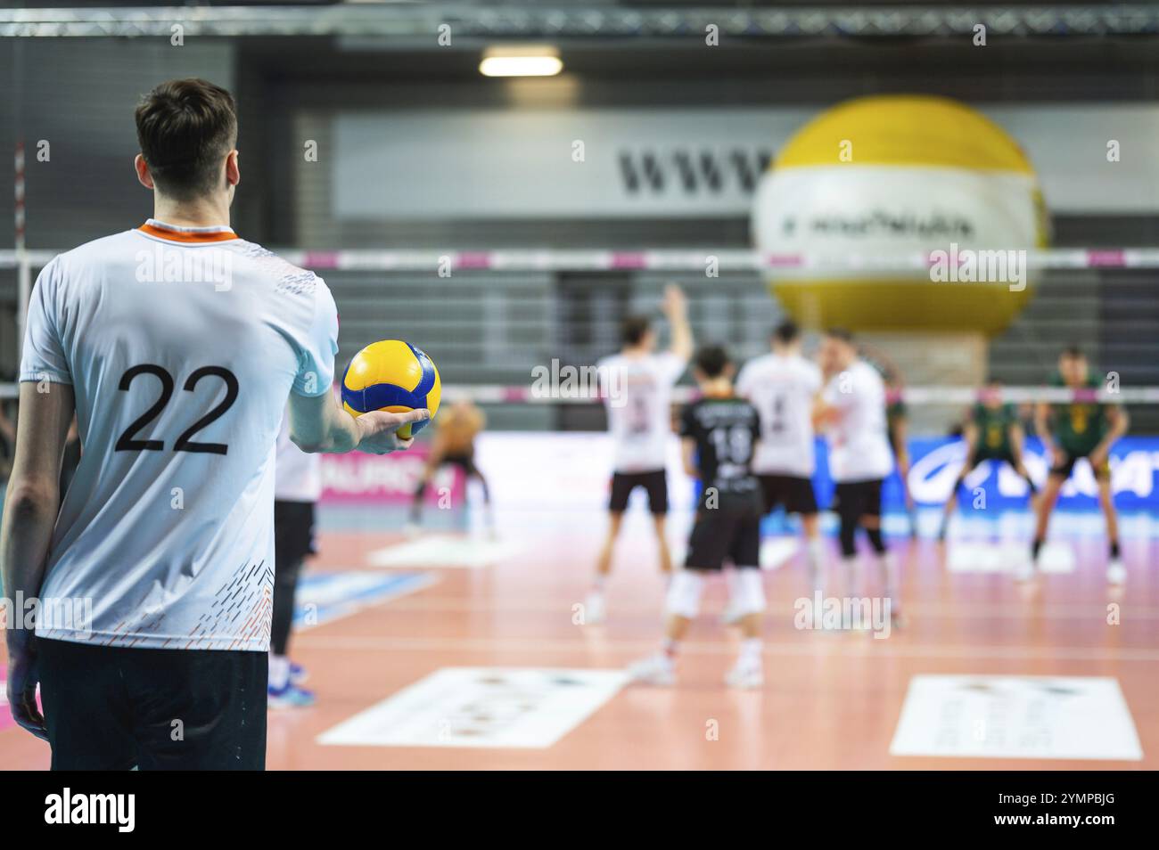 Der Volleyballspieler serviert während des Spiels Ball Stockfoto