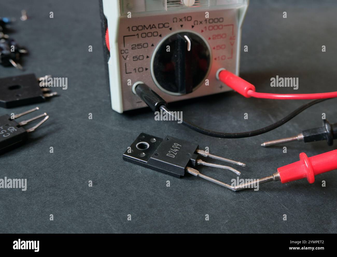 Ein Leistungstransistor auf dem Tisch mit dem Multimeter. Konzentriert sich auf die zu testende Komponente. Stockfoto