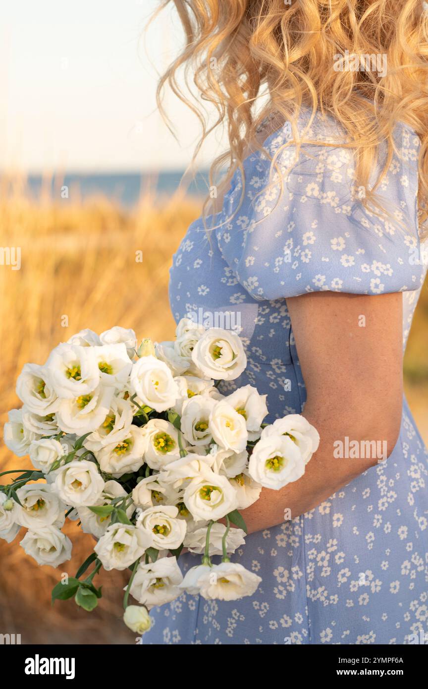 Weiße Blumen in den Händen einer Frau Stockfoto