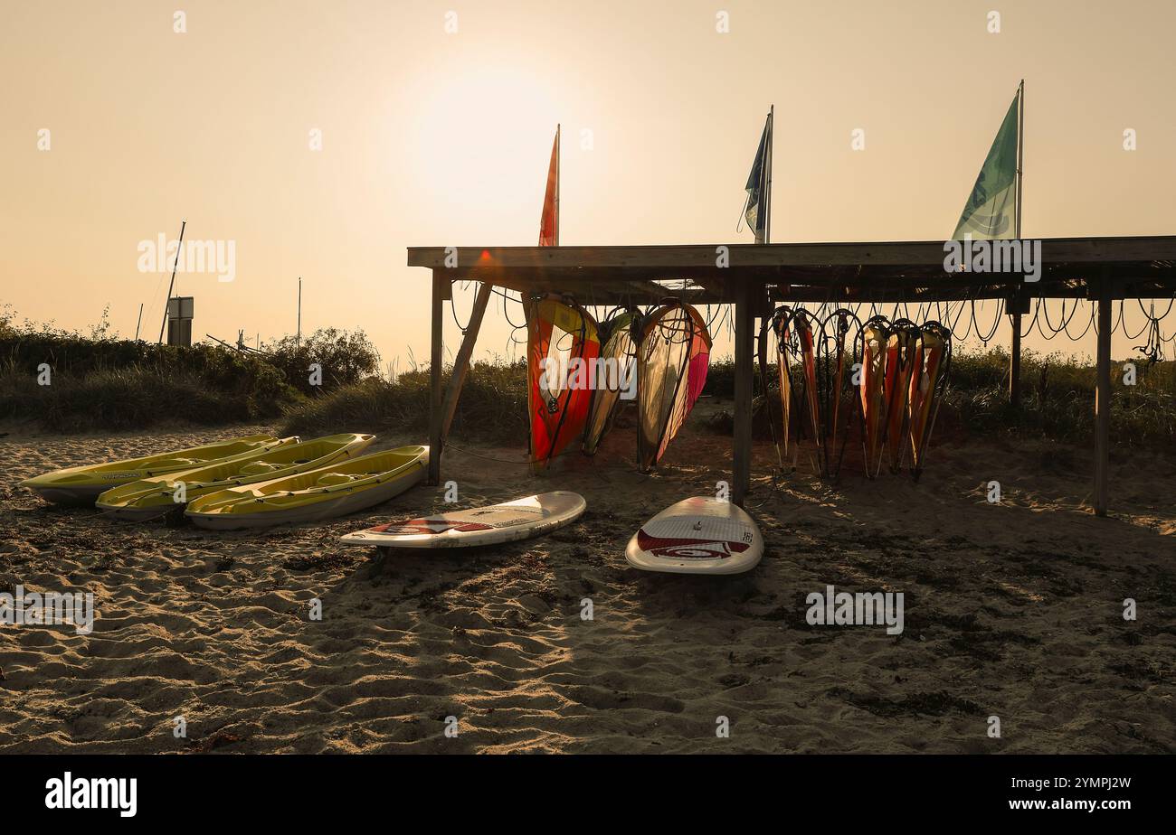 Eine Surfschule an der Ostsee. Die herrliche Abendsonne färbte die Surfausrüstung in wunderschönen Farben. Stockfoto