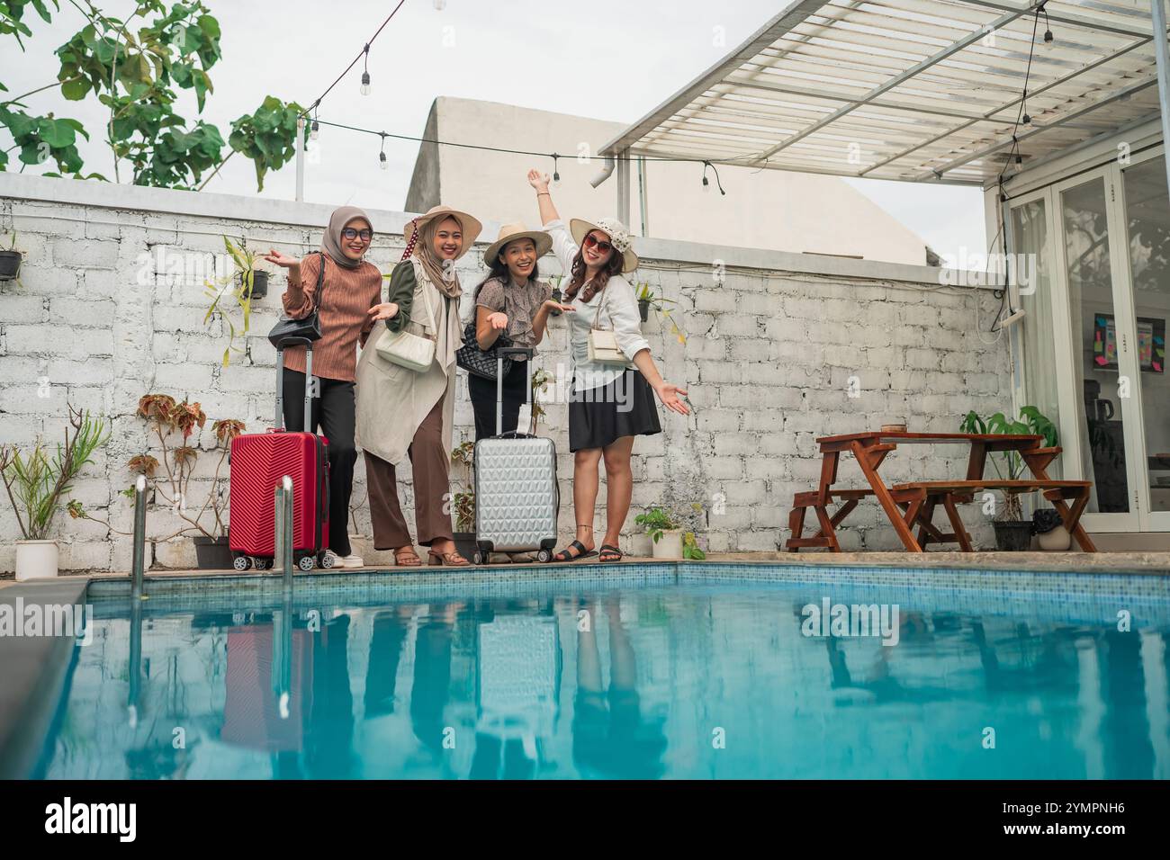 Eine Gruppe von Freunden, die ihr aufregendes Reiseabenteuer am Pool genießen Stockfoto
