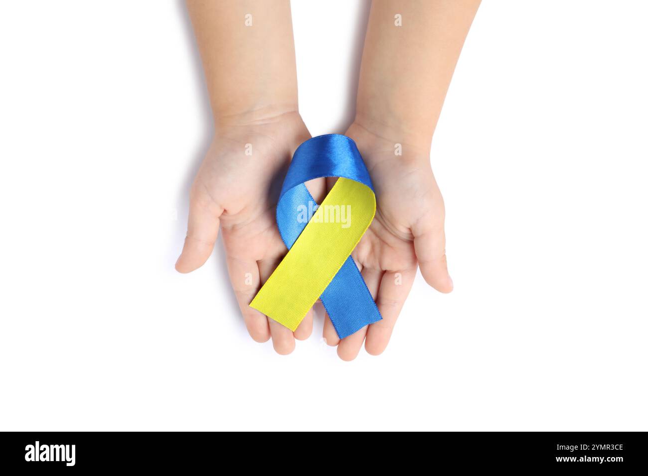 Kind mit gelbem und blauem Band auf weißem Hintergrund, Draufsicht. Down-Syndrom-Bewusstsein Stockfoto