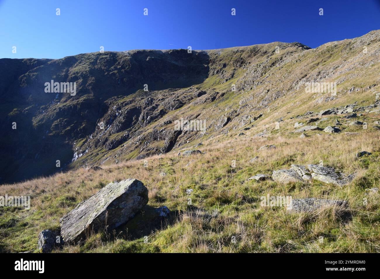 Sonnenlicht und Schatten an Blea Water und High Street Felswänden, English Lake District. Stockfoto