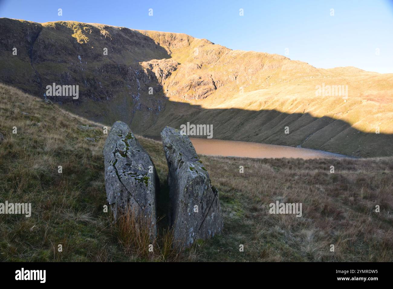 Sonnenlicht und Schatten an Blea Water und High Street Felswänden, English Lake District. Stockfoto