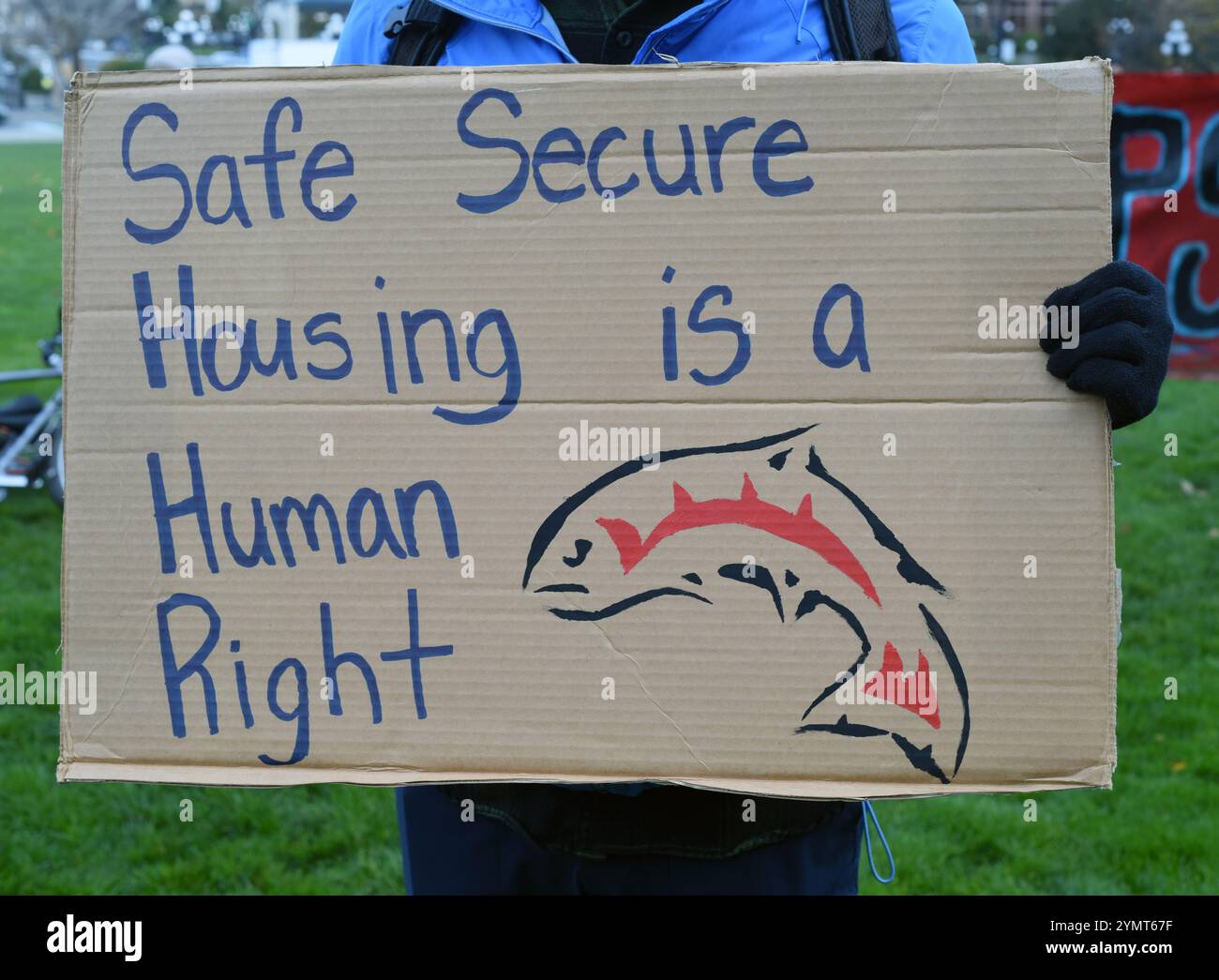 Victoria, British Columbia, Kanada, 22. November 2024 - Ein Demonstrant hält ein Schild auf einer Demonstration gegen die hohen Wohnkosten und die Notlage der Obdachlosen vor dem Parlamentsgebäude in Victoria, BC, Kanada. Don Denton/Alamy Live News Stockfoto