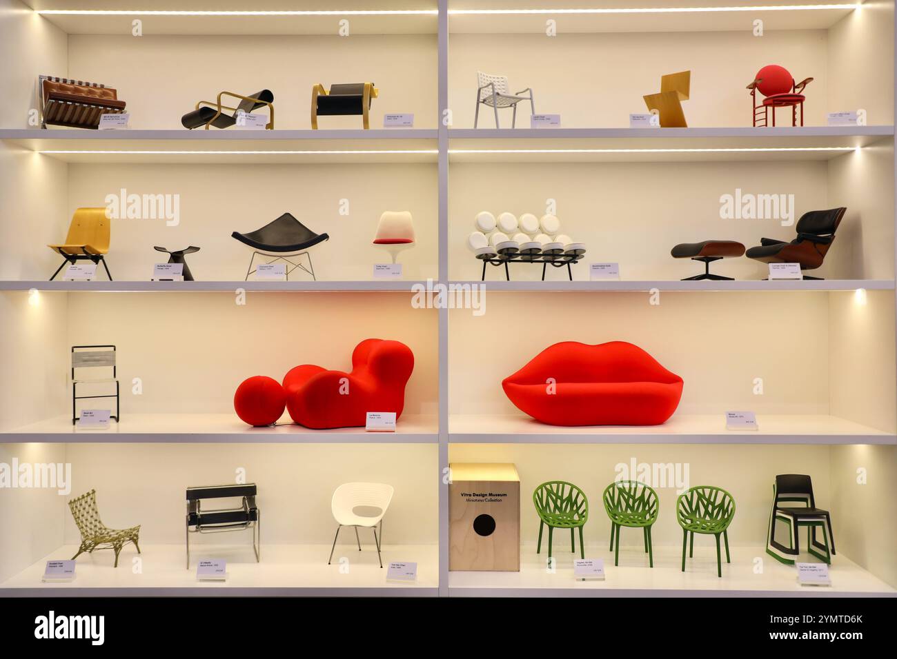 Miniaturen von Designerstühlen im Schaufenster des Vitra Museums weil am Rhein zeichnen die Geschichte des Designs nach. Von links nach rechts auf dem oberen Regal: MR. 90 Barcelona von Ludwig Mies van der Rohe, Art. 41 „Paimio“ und Sessel 42 von Alvar Aalto, Landi Chair von Hans Coray, Zick Zack stoel von Gerrit Rietveld und Johnson Wax Chair von Frank Lloyd Wright. Auf dem zweithöchsten Regal: Antony von Jean Prouvé, Butterfly Stool von Sori Yanagi, Coconut Chair von George Nelson, Tulip Chair von Eero Saarinen, Marshmallow Sofa von George Nelson und Lounge Chair & Ottoman von Charles & Ray EA Stockfoto