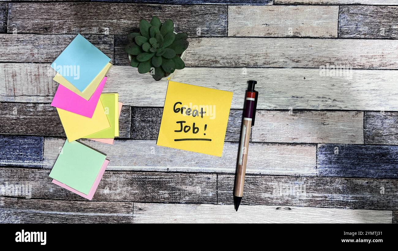 Das Konzept des „Great Job“ schreibt auf Haftnotizen, die auf einem Holztisch isoliert sind. Stockfoto