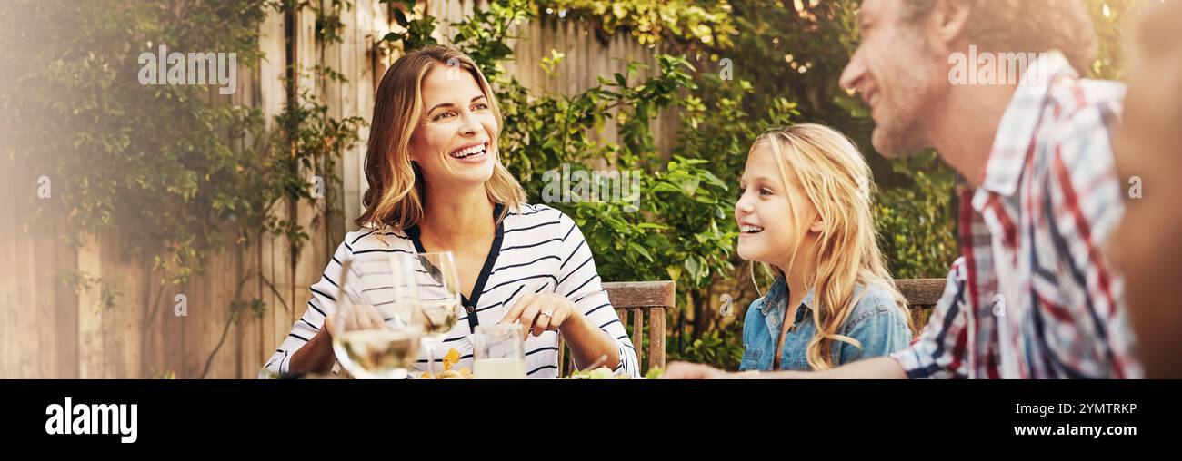 Mom, Dad und Kinder auf der Terrasse essen mit Lächeln, Bindungen und Familie essen zusammen im Garten. Vater, Mutter und Kinder am Tisch im Garten Stockfoto
