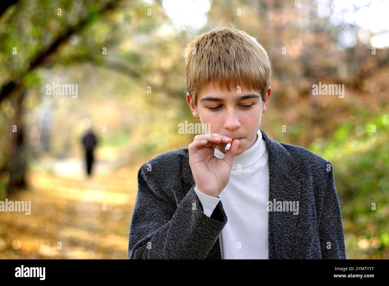 Problematischer Teenager, der im Park Zigarette raucht Stockfoto