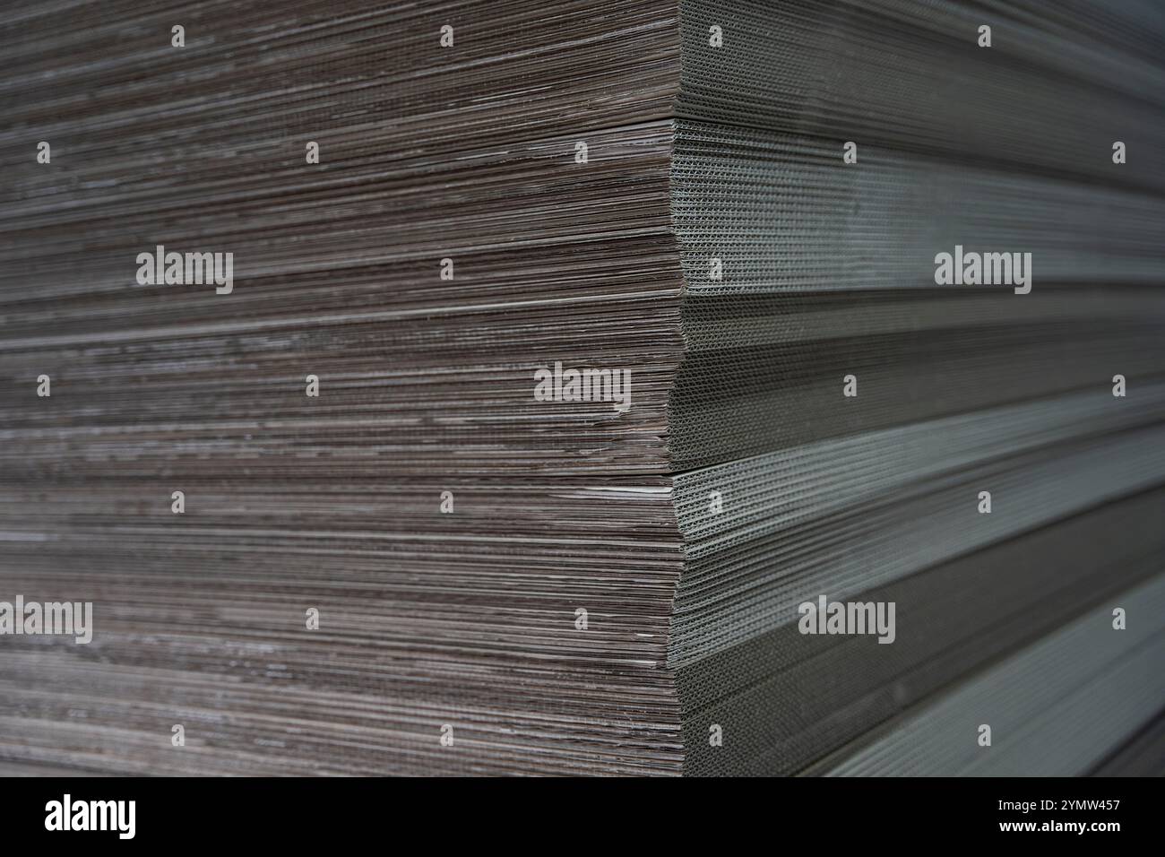 Textur der Pappnahmehilfe. Große Kartons werden in einem Werk zur Herstellung von Verpackungskartons gestapelt. Material für die Herstellung von Pappe Stockfoto