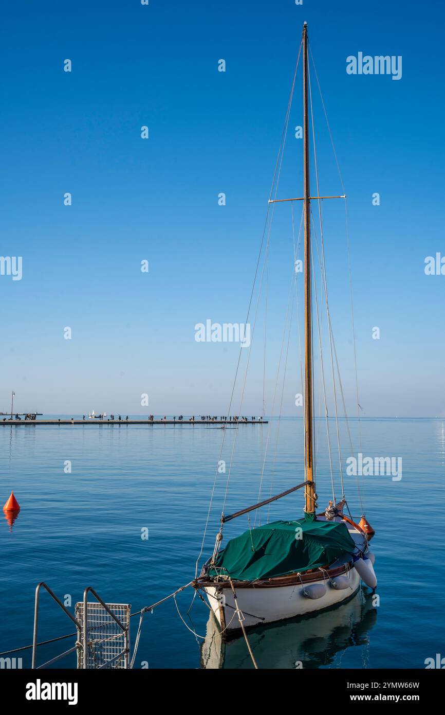 Wunderschönes Segelschiff mit 'Molo Audace' Pier entlang der Küste von Triest, das sich im Hintergrund im Meer erstreckt. Piazza Unità d'Italia. Stockfoto