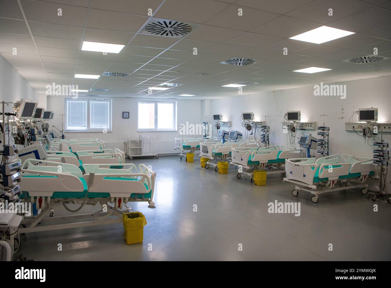 Moderne Technik in leerem Intensivraum mit verschiedenen Geräten, Betten und Kissen. Stockfoto