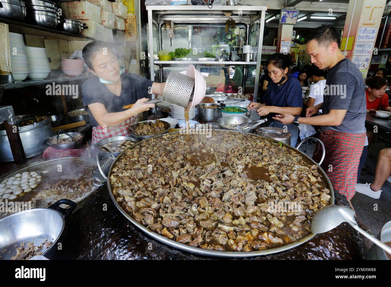 Bangkok, Thailand - 27. Juni 2023: Im Restaurant Wattana Panich wird eine riesige Pfanne mit gedünstetem Rindfleisch und Ziegenfleisch gesehen. Stockfoto