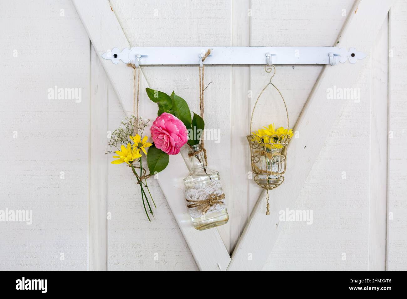 Rustikale weiße Scheune Hochzeit mit elegantem floralen Wandhintergrund Stockfoto