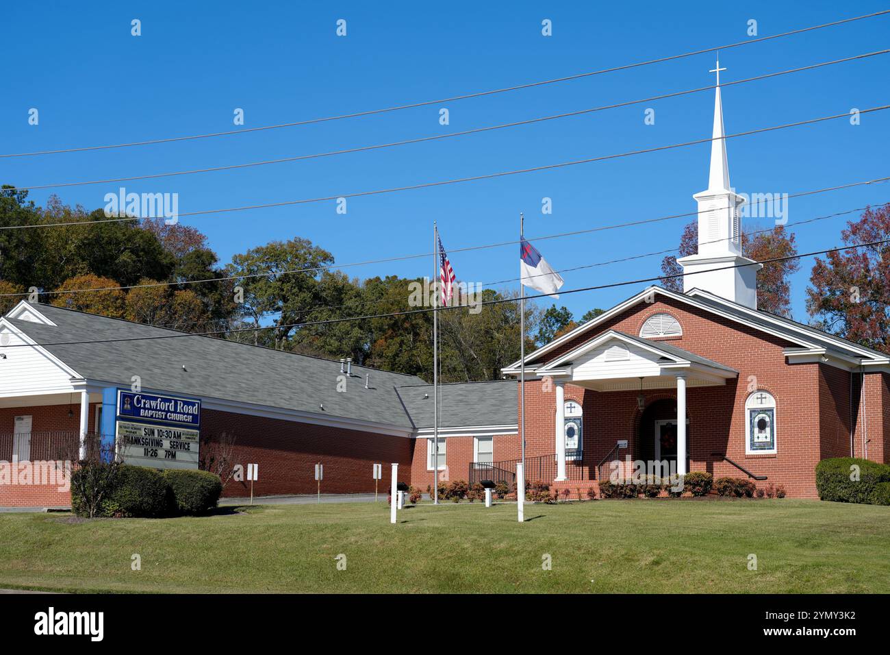 Phoenix City, Alabama, USA. November 2024. Die „˜Christian Flag“ wird am 23. November 2024 neben der Flagge der Vereinigten Staaten vor der Crawford Road Baptist Church in Phoenix City, Alabama, gesehen. Die ursprünglich 1897 entworfene und 1942 vom Federal Council of Churches der Vereinigten Staaten verabschiedete christliche Flagge wurde in den letzten Jahren mit der rechtsextremen Politik in Verbindung gebracht, was dazu führte, dass einige Kirchen sie niedernahmen und andere symbolisch die Flagge hissen. Quelle: ZUMA Press, Inc./Alamy Live News Stockfoto