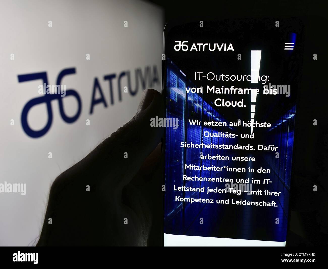 Stuttgart, 15.07.2024: Handybesitzer mit Webseite des deutschen IT-Unternehmens Atruvia AG vor Logo. Konzentrieren Sie sich auf c Stockfoto