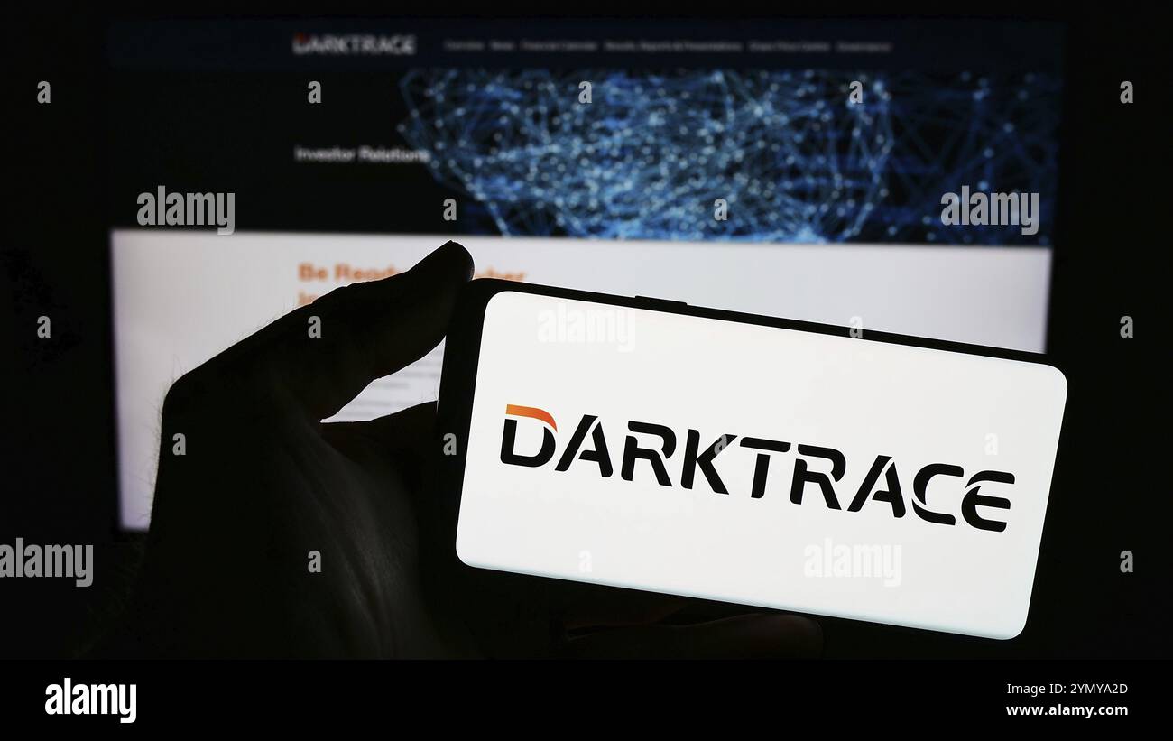 Stuttgart, Deutschland, 17.03.2024: Person, die ein Smartphone mit dem Logo des britischen Cybersicherheitsunternehmens Darktrace plc vor der Website hält. Konzentrieren Sie sich auf Phon Stockfoto